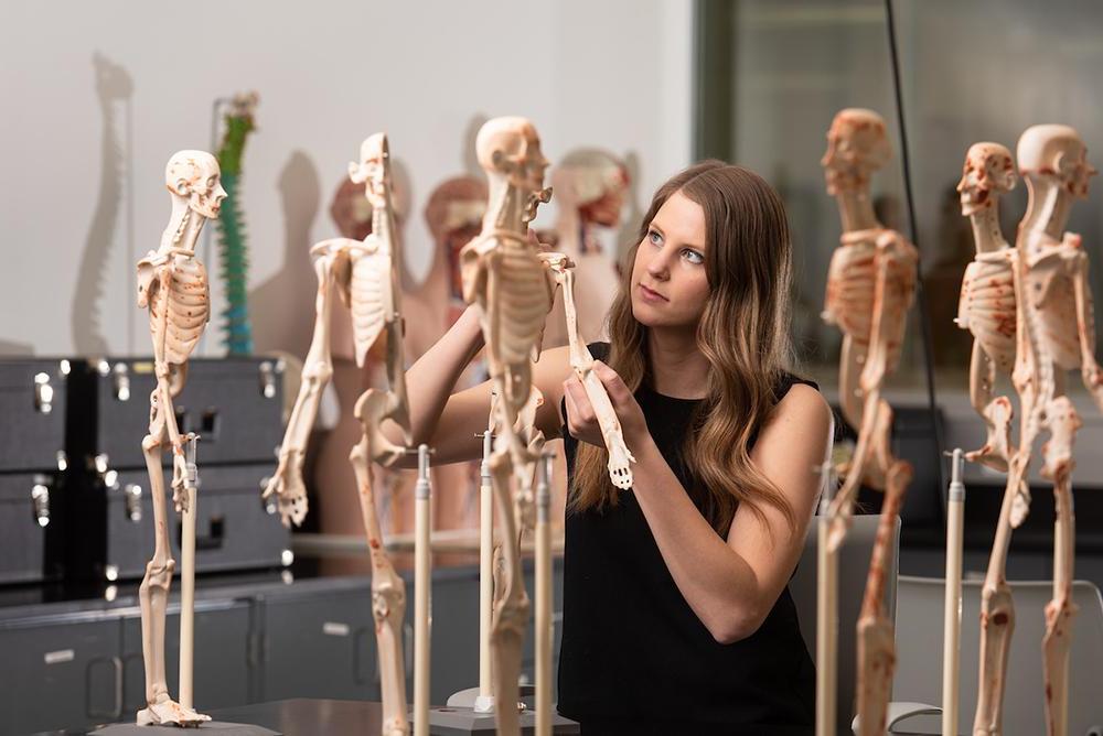 student inspecting skeleton