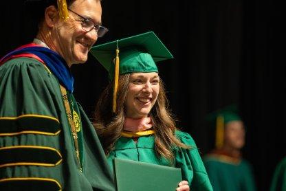 Photo of a student and President David Cook at spring commencement